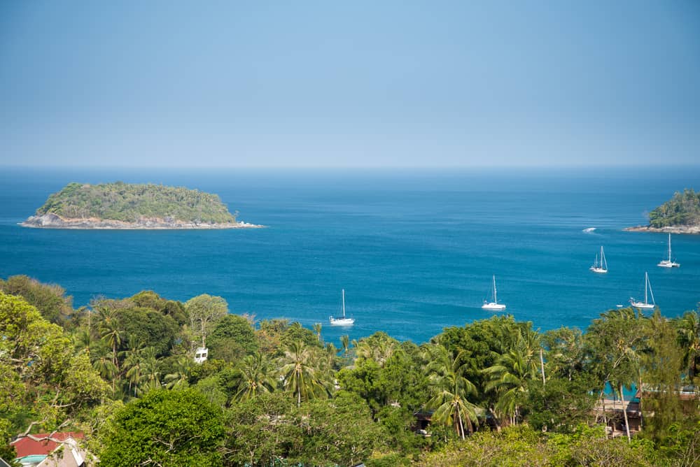 Image of the sea with trees in the foreground at Nai Yang Beach in Phuket